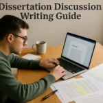 Student writing a dissertation discussion chapter on a laptop