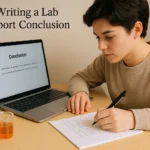 Student writing a conclusion in a lab report with notes and laptop